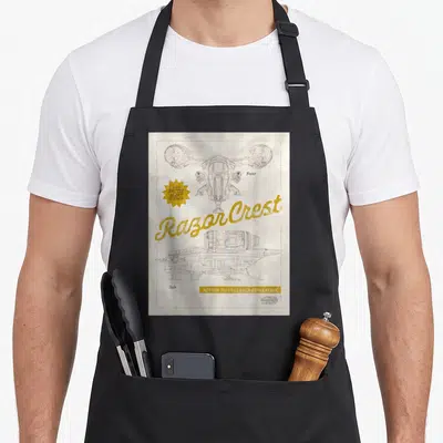 Tablier de cuisine noir avec schéma technique de la Razor Crest et texte Razor Crest en lettres dorées sur fond vieilli.
