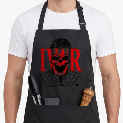 Tablier de cuisine noir avec illustration d'un crâne viking coiffé de tresses et le mot IVAR en lettres rouges majuscules.