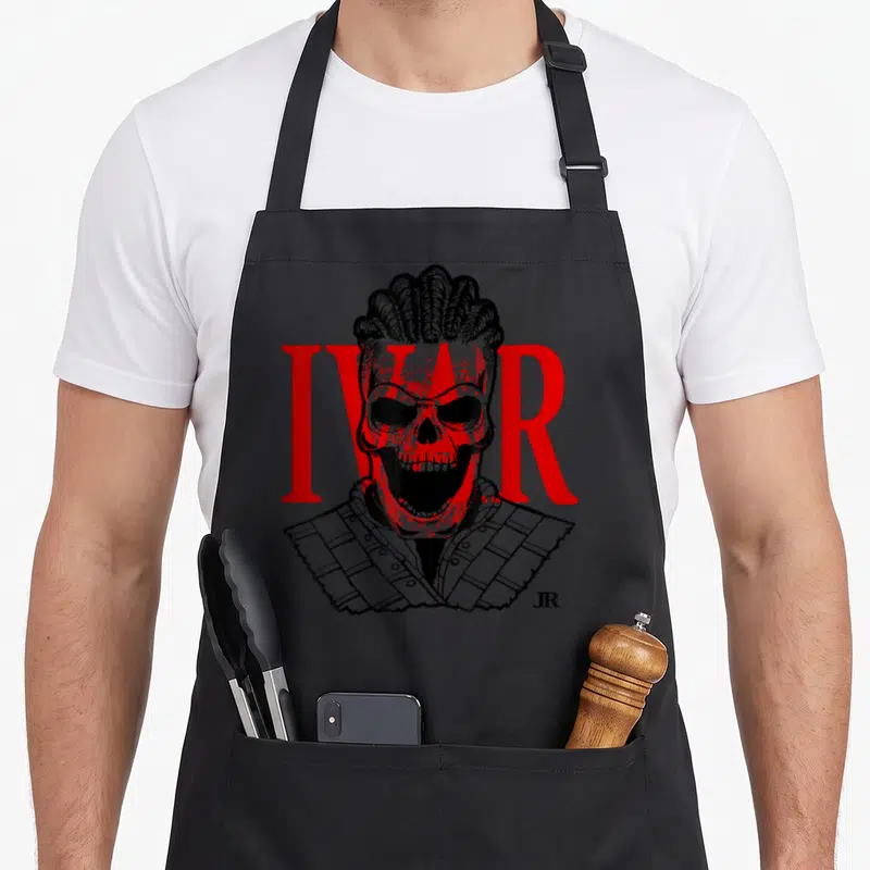Tablier de cuisine noir avec illustration d'un crâne viking coiffé de tresses et le mot IVAR en lettres rouges majuscules.