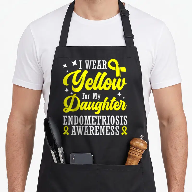 Tablier de cuisine noir avec texte jaune et blanc « I WEAR Yellow For My Daughter ENDOMETRIOSIS AWARENESS » et rubans jaunes.