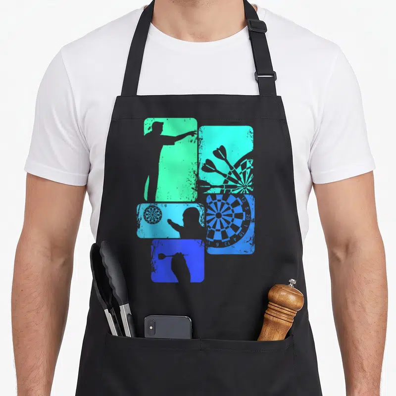 Tablier de cuisine noir avec silhouettes de joueurs de fléchettes et cibles en bleu et vert sur fonds rectangulaires texturés.