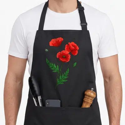 Tablier de cuisine noir avec illustration de trois coquelicots rouges fleur nature botanique floral et feuilles découpées vertes.