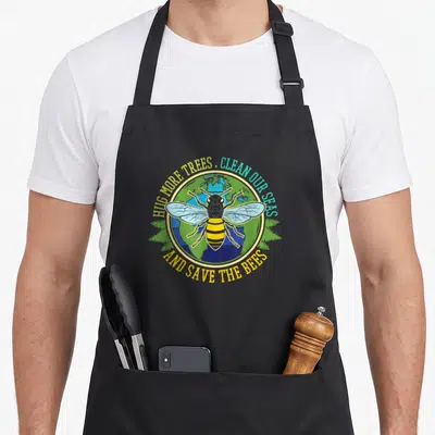 Tablier de cuisine noir avec une illustration circulaire d'une abeille sur un globe terrestre entouré de texte en anglais.