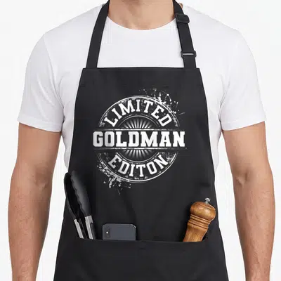 Tablier de cuisine noir avec logo circulaire blanc Limited Goldman Editon et effet éclaboussure.
