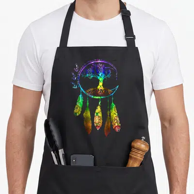 Tablier de cuisine noir avec attrape-rêves arc-en-ciel, arbre de vie central et cinq plumes décoratives aux motifs complexes.