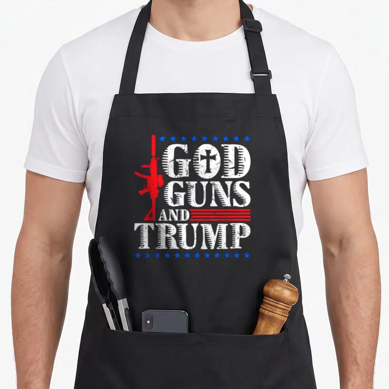 Tablier de cuisine noir avec inscription Dieu Armes et Trump et fusil rouge stylisé.