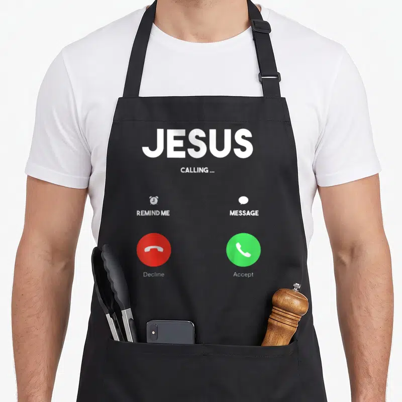Tablier de cuisine noir avec interface d'appel blanc, boutons verts et rouges ainsi que le texte Jesus is Calling.
