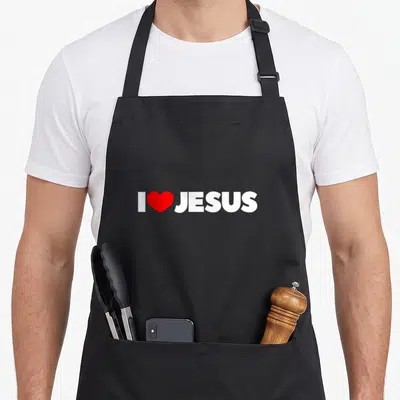 Tablier de cuisine noir avec l'inscription I Love Jesus et un cœur rouge au centre du motif.