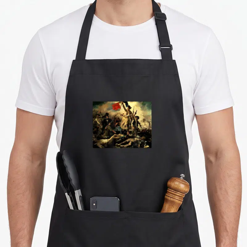 Tablier de cuisine noir avec reproduction de la Liberté qui conduit le peuple de Delacroix imprimée sur le devant.