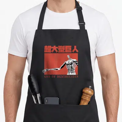 Tablier de cuisine noir avec illustration d'un Titan musclé blanc sur fond rouge et texteGod of Destruction en bas.