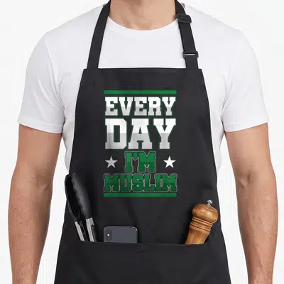 Tablier de cuisine noir avec l'inscription Every Day I'm Muslim en vert et blanc encadré d'étoiles.