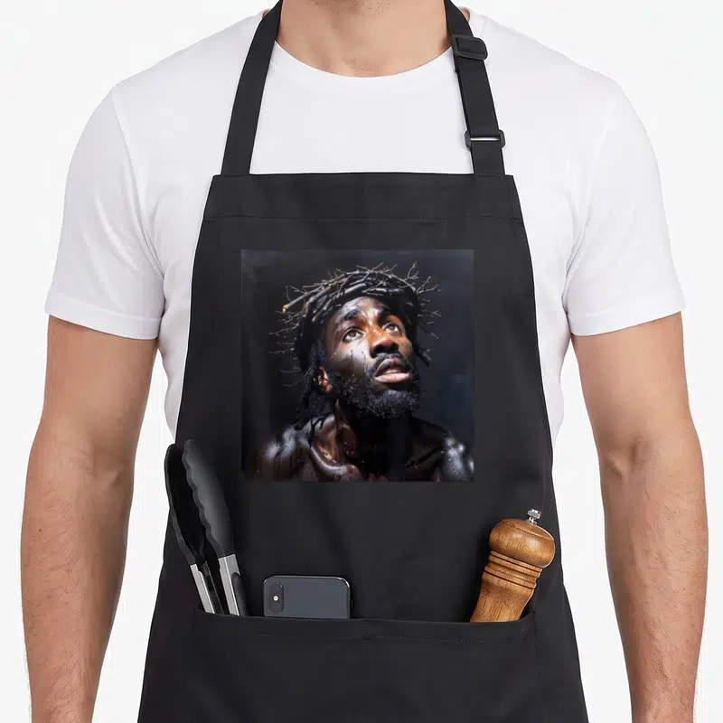 Tablier de cuisine noir avec portrait réaliste d'un homme noir couronné d'épines regardant vers le haut, style peinture sombre.