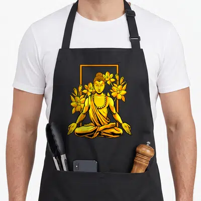 Tablier de cuisine noir avec Gautama Bouddha assis en tailleur entouré de fleurs jaunes et d'un cadre orange.