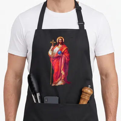 Tablier de cuisine noir avec une illustration colorée de Jésus Christ tenant un sceptre et une sphère bleue.