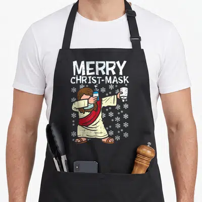 Tablier de cuisine noir avec une illustration de Jésus effectuant un mouvement de danse moderne tout en tenant un flacon désinfectant.