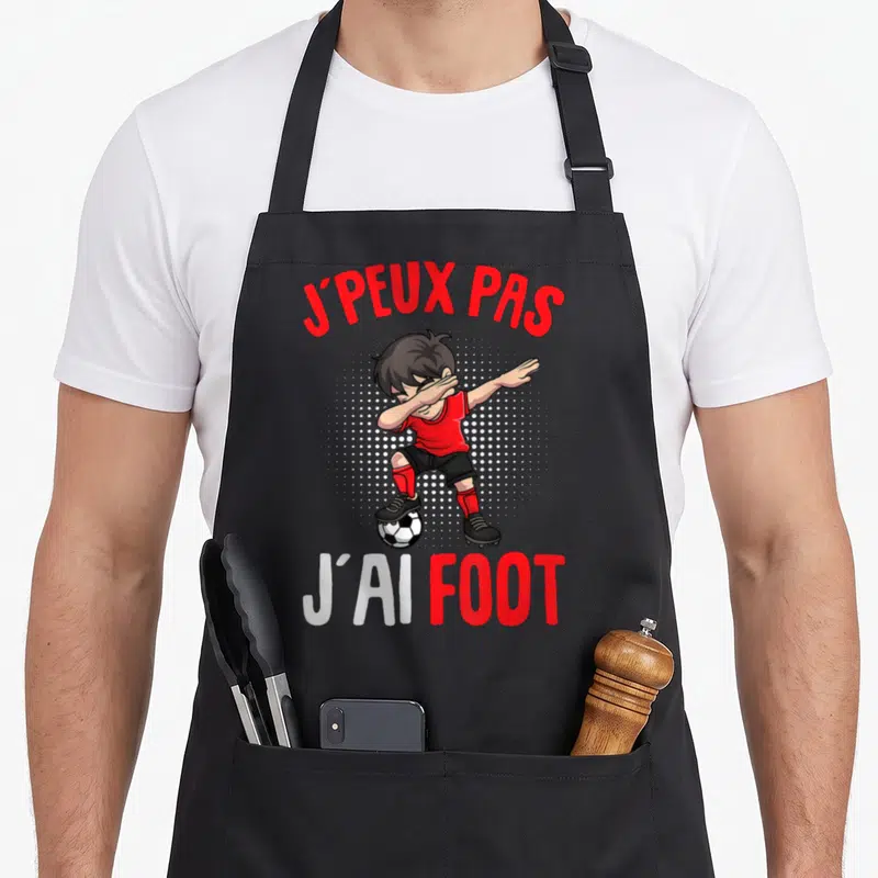 Tablier de cuisine noir avec illustration d'un garçon faisant un dab sur un ballon et texte J'peux pas j'ai foot