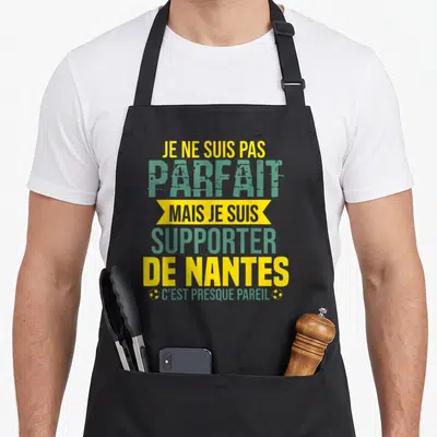 Tablier de cuisine noir avec le texte Je ne suis pas parfait mais je suis supporter de Nantes en jaune et vert.