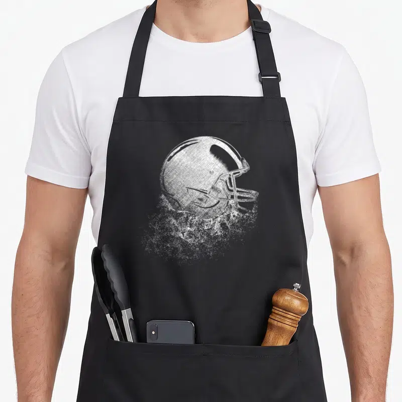 Tablier de cuisine noir avec illustration blanche d'un casque de football américain en style pointilliste.