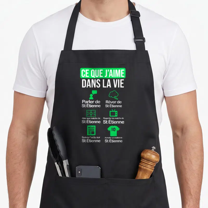 Tablier de cuisine noir avec le texte Ce que j'aime dans la vie et des icônes vertes sur fond gris.