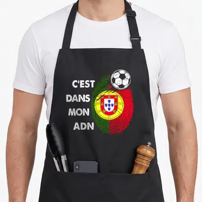 Tablier de cuisine noir avec une empreinte digitale aux couleurs du Portugal et un ballon de foot blanc en haut à droite.