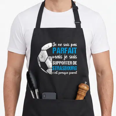 Tablier de cuisine noir avec illustration de ballon de football et texte blanc et bleu.