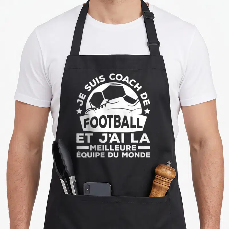 Tablier de cuisine noir avec illustration blanche d'une bottine de foot et le texte Je suis coach de football et j'ai la meilleure équipe du monde.