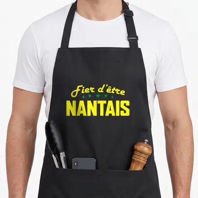 Tablier de cuisine noir avec inscription Fier d'être Nantais en lettres jaunes et étoiles vertes au centre du torse.