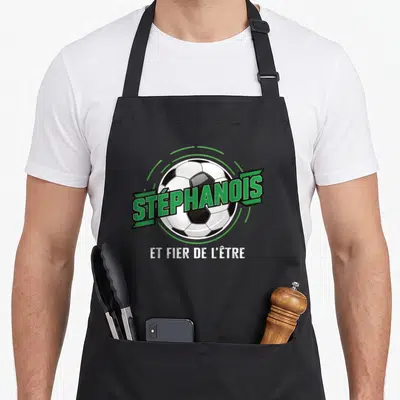 Tablier de cuisine noir avec un ballon de foot et le texte Stéphanois et fier de l'être en vert et blanc.