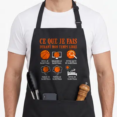 Tablier de cuisine noir avec des illustrations de ballon orange et du texte blanc sur les loisirs du joueur.