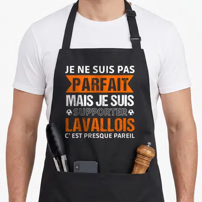 Tablier de cuisine noir avec inscription blanche et orange Je ne suis pas parfait mais je suis Lavallois c'est presque pareil encadré par deux petits ballons de foot.