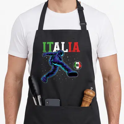Tablier de cuisine noir avec illustration d'un astronaute frappant un ballon aux couleurs du drapeau italien sur fond étoilé.