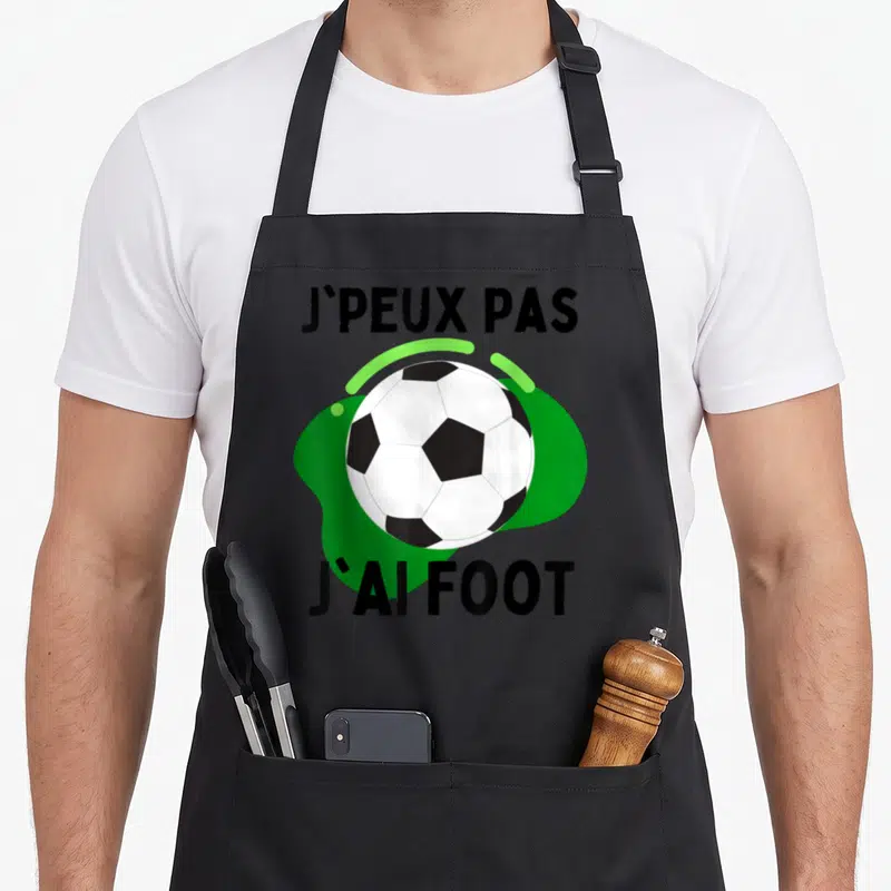 Tablier de cuisine noir avec un ballon de foot et le texte J'peux pas j'ai foot imprimé en noir et vert.