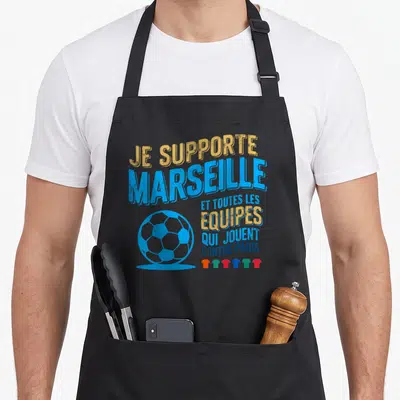 Tablier de cuisine noir avec le texte Je supporte Marseille et un ballon de foot bleu stylisé sur le devant.