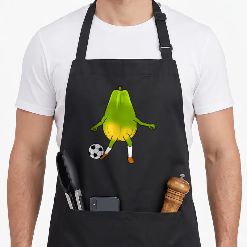 Tablier de cuisine noir avec illustration d'un joueur mignon ballon de papaye en train de jouer au foot.