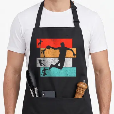 Tablier de cuisine noir avec silhouettes de joueurs de handball sur bandes rouges oranges blanches et bleues