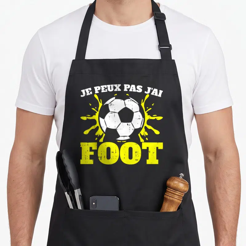 Tablier de cuisine noir avec inscription Je peux pas j'ai foot et illustration de ballon blanc.