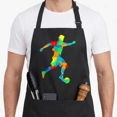 Tablier de cuisine noir avec silhouette de footballeur aux couleurs vives et style éclaboussure.