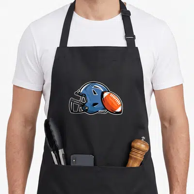 Tablier de cuisine noir avec un casque de football américain bleu et un ballon orange à lacets blancs.
