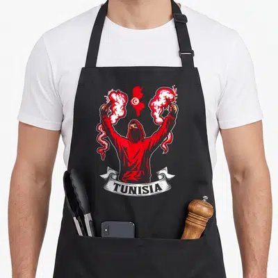 Tablier de cuisine noir avec illustration d'un supporter tunisien brandissant des fumigènes rouges et le drapeau national.