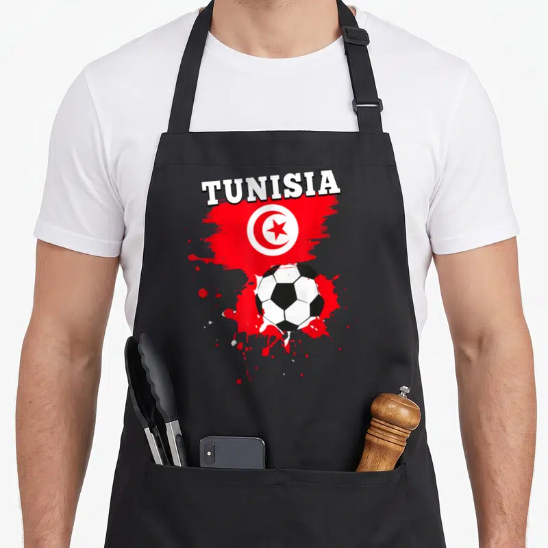 Tablier de cuisine noir avec illustration du drapeau tunisien, du mot TUNISIA et d'un ballon de football classique.