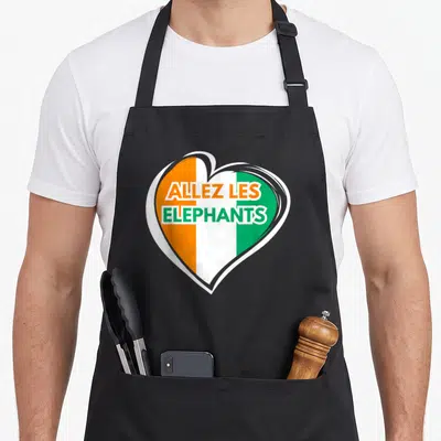 Tablier de cuisine noir avec un cœur aux couleurs du drapeau ivoirien et le texte Allez les Elephants en orange et vert.