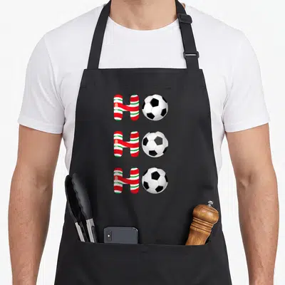 Tablier de cuisine noir avec trois ballons de foot et lettres H rayées rouges blanches et vertes alignées verticalement.