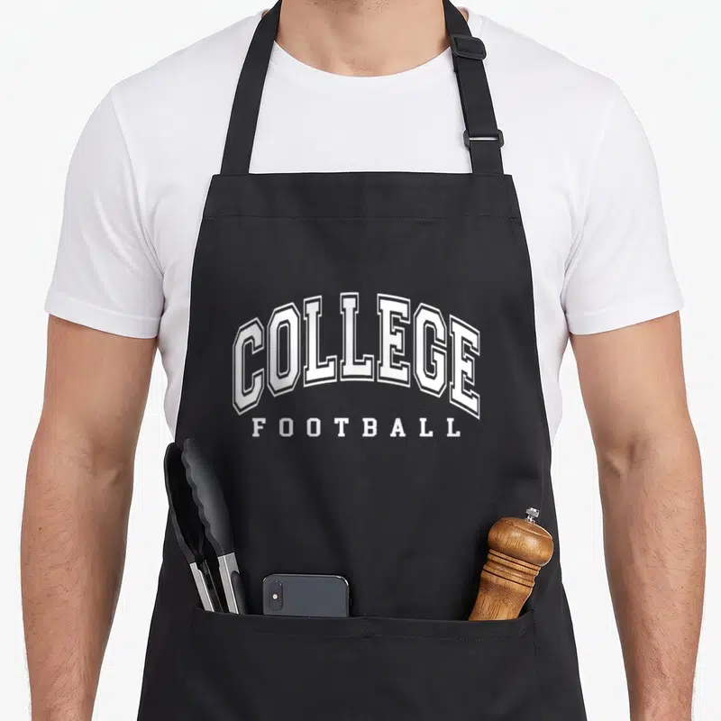 Tablier de cuisine noir avec l'inscription COLLEGE FOOTBALL en lettres blanches stylisées style campus américain.
