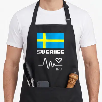 Tablier de cuisine noir avec drapeau bleu jaune SVERIGE et ligne de battement de cœur blanc.