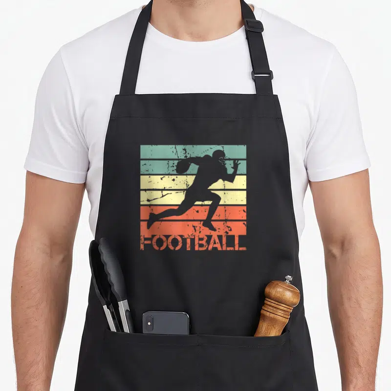 Tablier de cuisine noir avec silhouette joueur de football américain courant sur fond de bandes retro colorées et texte Football orange.