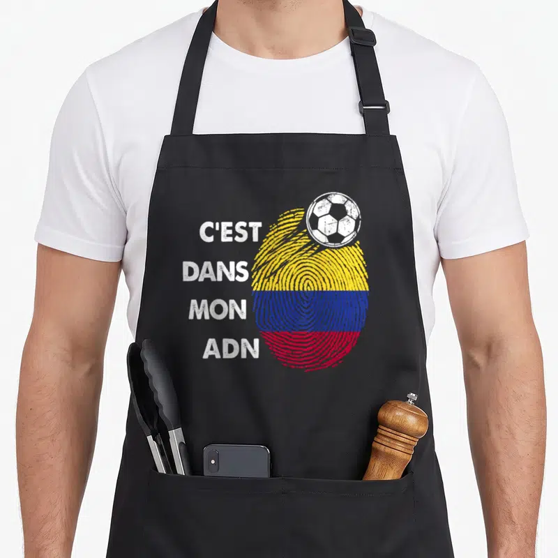 Tablier de cuisine noir avec une empreinte digitale aux couleurs du drapeau Colombie et un ballon de foot blanc posé dessus.