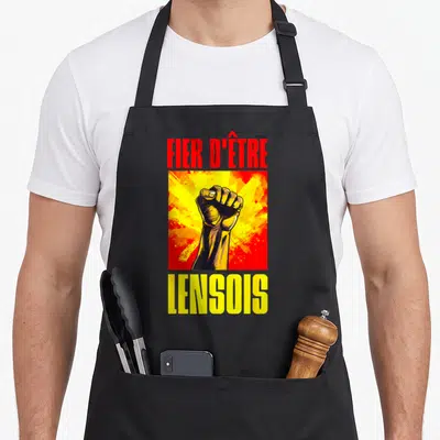Tablier de cuisine noir avec illustration poing levé et texte Fier d'être Lensois en rouge et jaune.