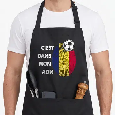 Tablier de cuisine noir avec une empreinte digitale aux couleurs du drapeau Roumanie et un ballon de football blanc en haut à droite.