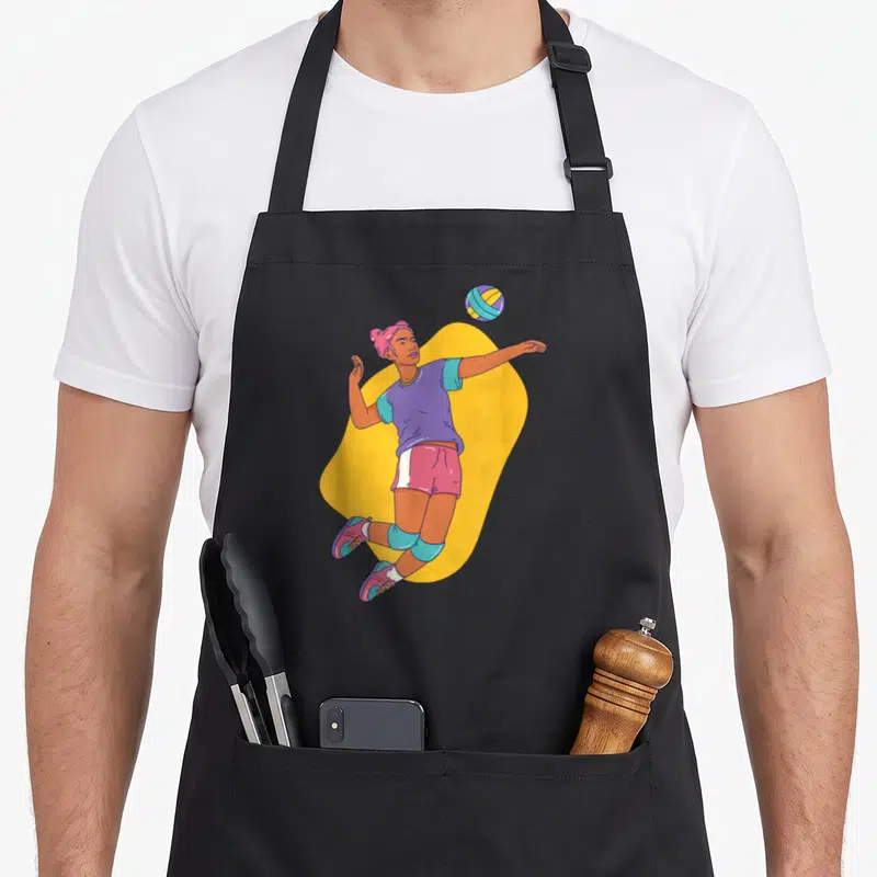 Tablier de cuisine noir avec illustration d'une femme joueuse de volley-ball sautant vers la balle.