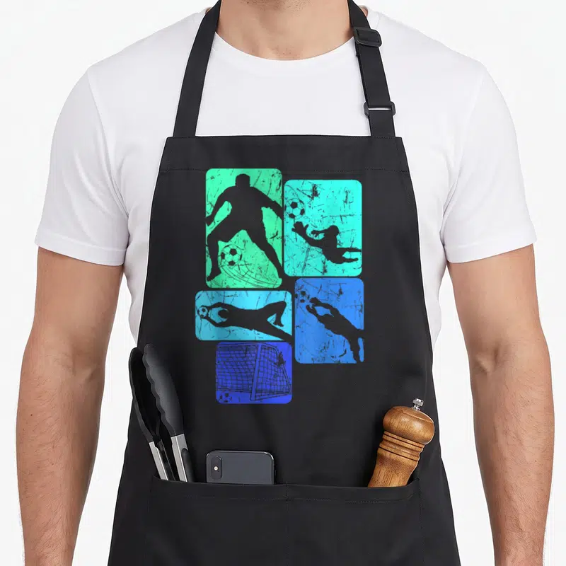Tablier de cuisine noir avec silhouettes de gardien de but sur fonds bleus et verts texturés.